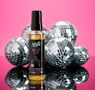 A bottle of Ampoule Intense and and five little disco balls behind it