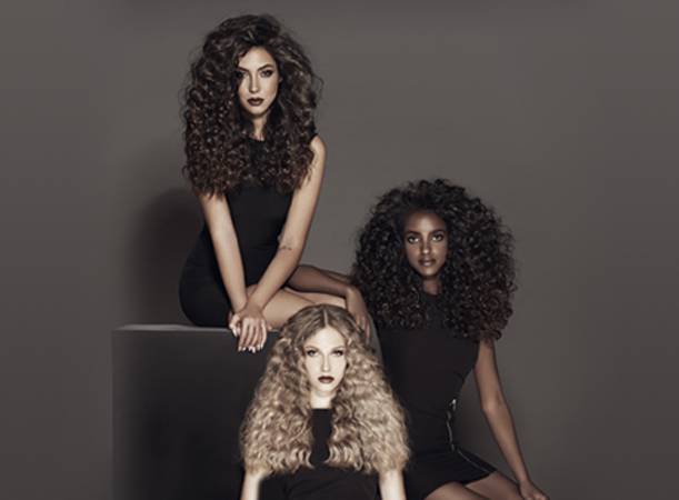 Three women with curly hair . The women's hair colors are brown, black and blonde