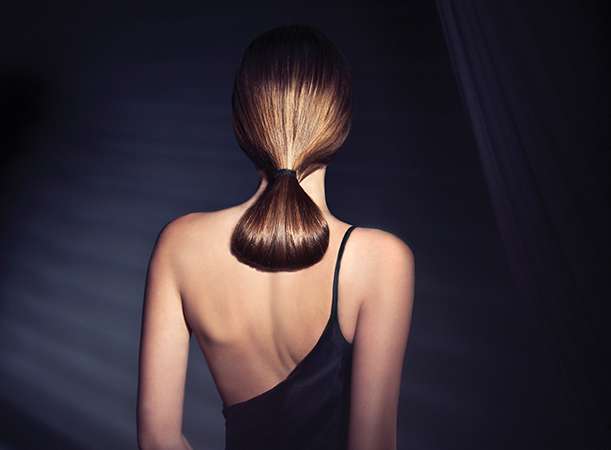 A woman with straightened brown low ponytail